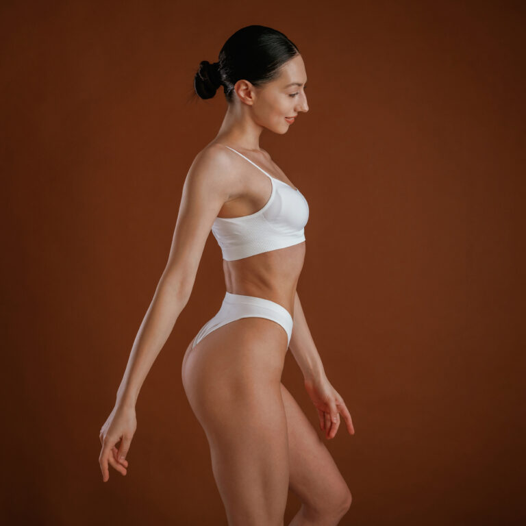 New underwear collection. Woman with slim body shape is posing against background.